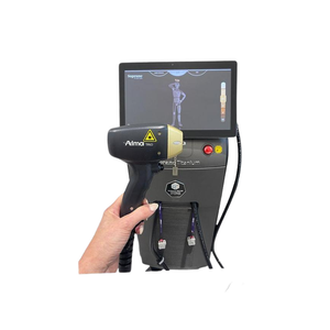 2023 Alma Soprano Titanium controller view showing a hand holding the handpiece with its display screen and coiled cable attached to the base unit