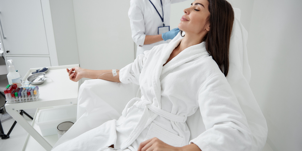 Girl receiving IV therapy while lying down for enhanced wellness and nutrient replenishment