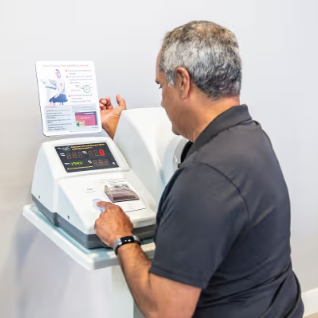 A man using an InBody blood pressure kiosk with a white background