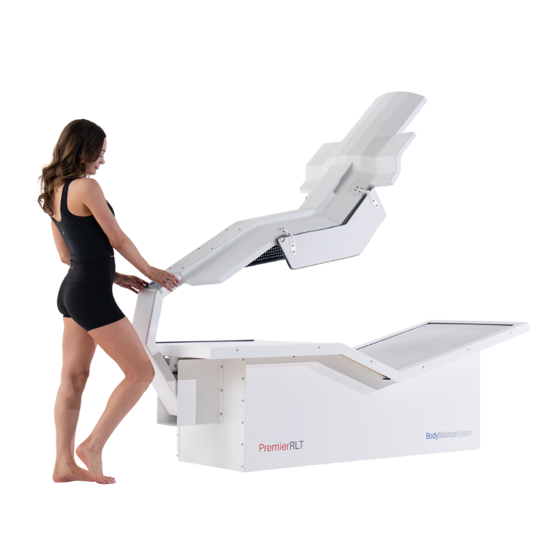 Body Balance System Premier RLT red light therapy bed on a white background with model operating the system