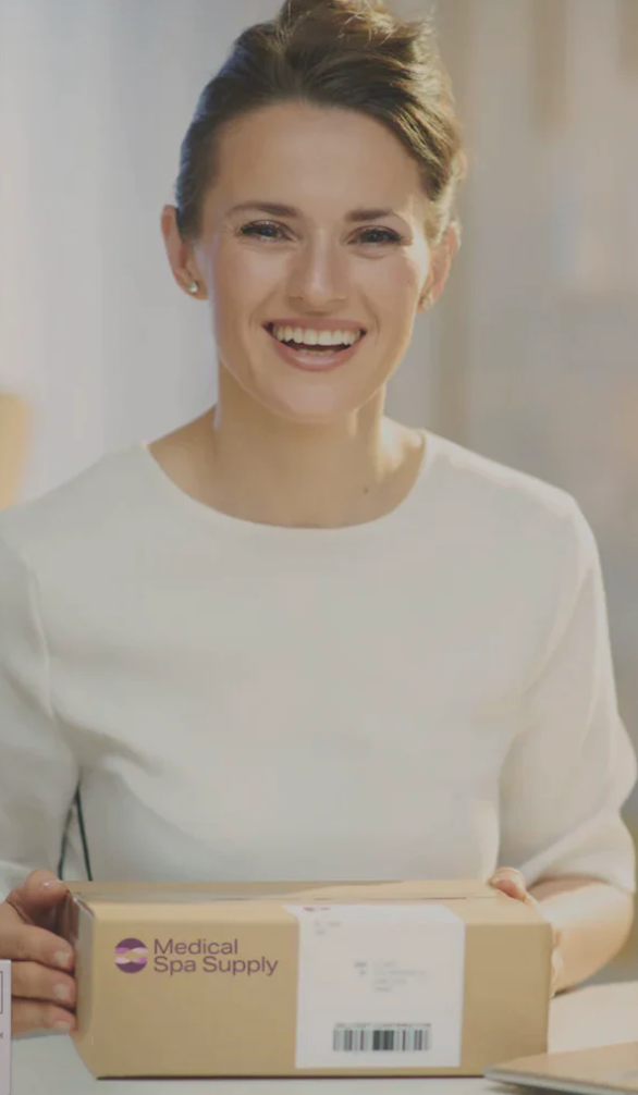 Smiling woman with Medical Spa Supply box of med spa supplies